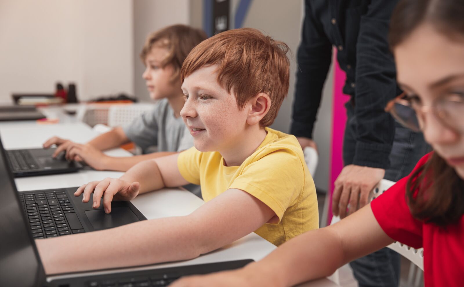 Vaikai dalyvauja programavimo būrelio pamokoje, kur mokyti programavimo padeda lavinti loginį mąstymą ir kūrybiškumą