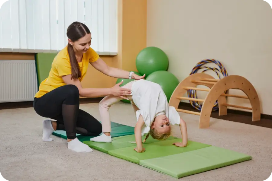 Vaikai dalyvauja gimnastikos būrelio pamokoje Kūdikių ir vaikų gimnastikos mokykloje